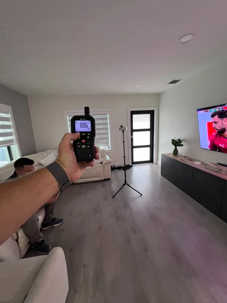 Calibrated air sampling pump mounted on a tripod collecting an indoor air sample in a living room