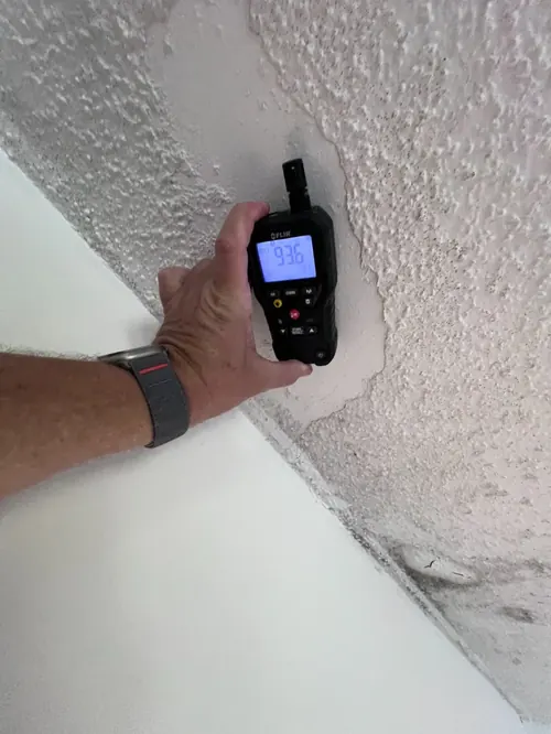 Moisture meter reading 93 percent at a stained ceiling corner during a roof leak investigation in Pembroke Pines, FL