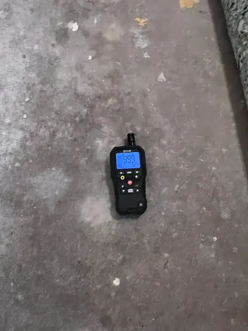 Moisture meter reading maximum saturation on a concrete garage slab in Sunny Isles Beach, FL