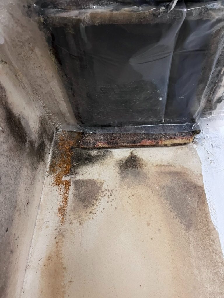 Rust bleed and mold growth at an HVAC duct connection seam