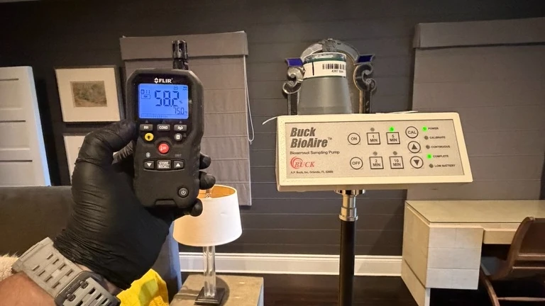 Buck BioAire air sampling pump on a tripod in a residential room