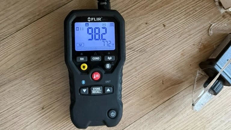 Moisture meter showing an elevated reading on residential flooring