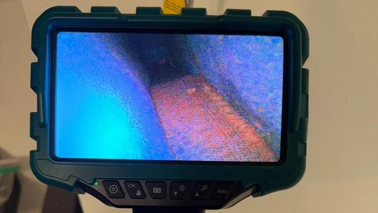 Inspector viewing a concealed building cavity on a handheld borescope display