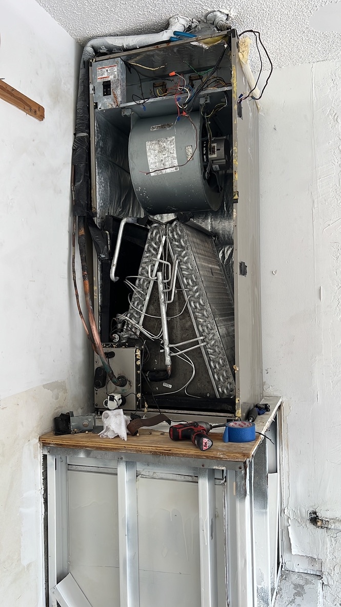 Open air handler unit showing the evaporator coil and blower assembly during an HVAC mold inspection