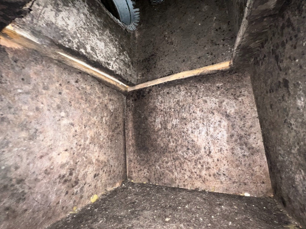Interior of an air duct showing heavy dark mold contamination inside the ductwork