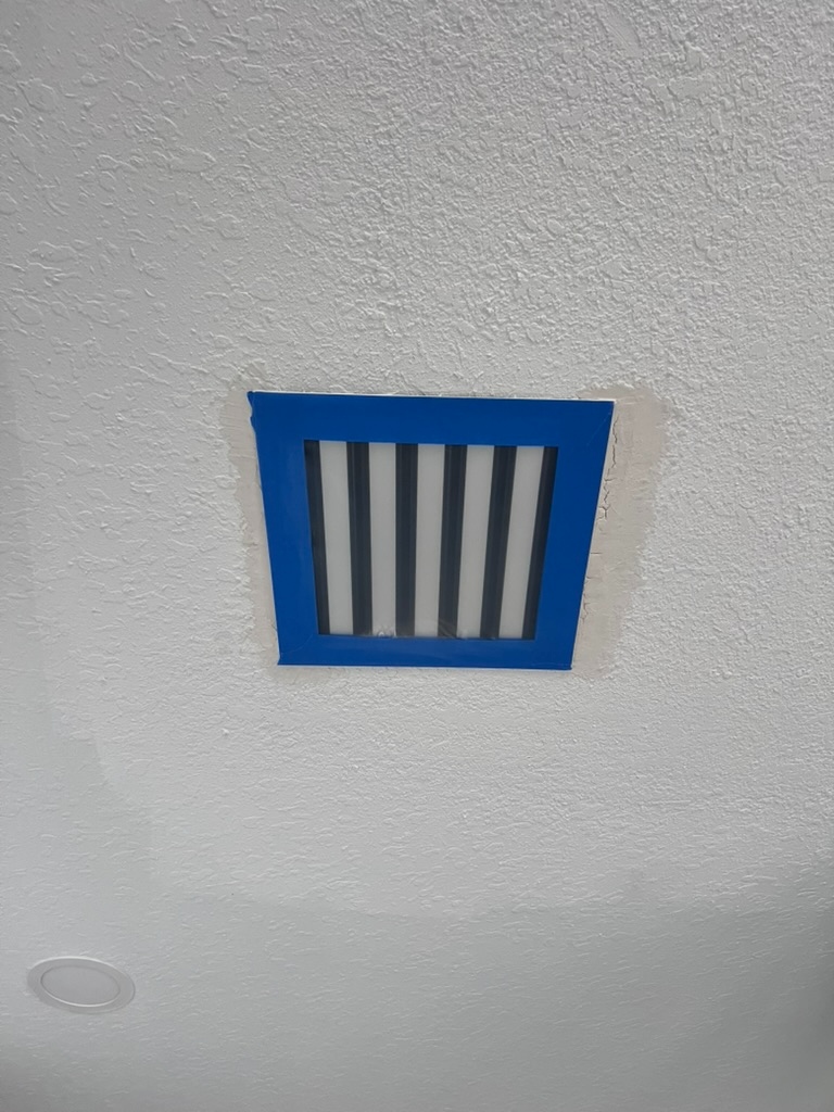 HVAC air vent sealed with blue tape for remediation containment