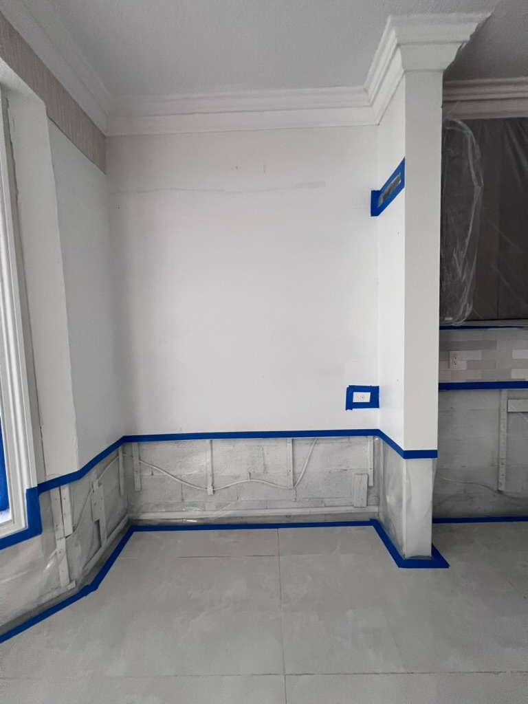 Wall and baseboard remediation area taped and prepped for clearing