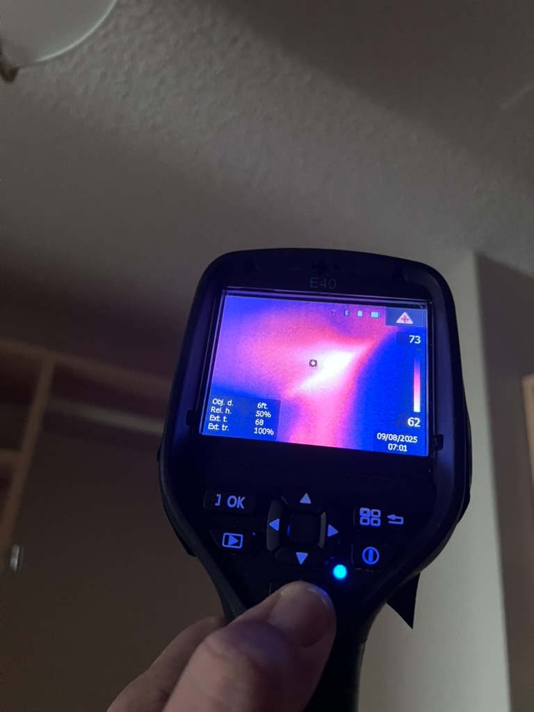 FLIR thermal camera reading a thermal anomaly on a bedroom ceiling near a closet