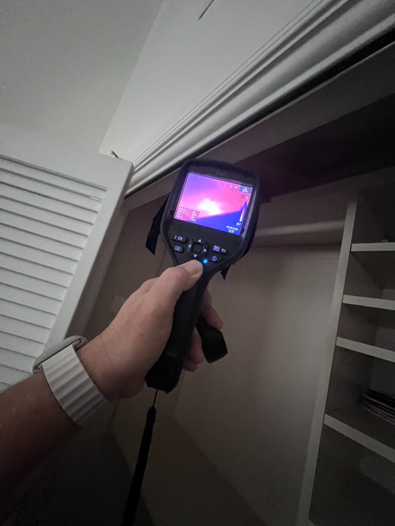FLIR thermal camera reading a temperature anomaly above a closet doorway frame