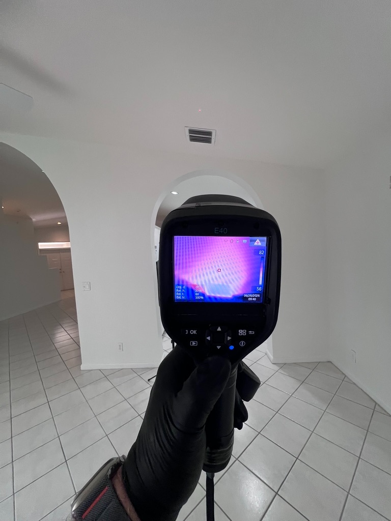 FLIR thermal camera reading a cool spot near a ceiling and wall corner