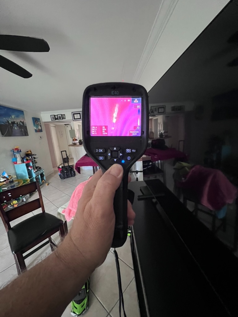 FLIR thermal camera reading a heat signature on a living room wall unit